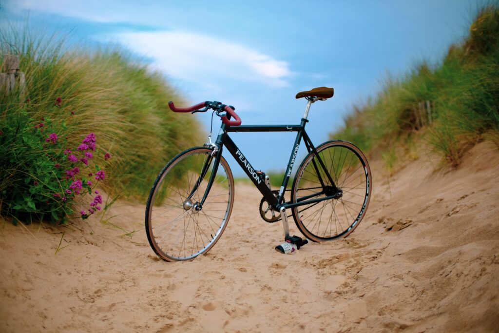 Bilden visar en cykel på stranden. Cykelparkering och cykelrum med fristående cykelställ är praktiskt för förvaring av din cykel.